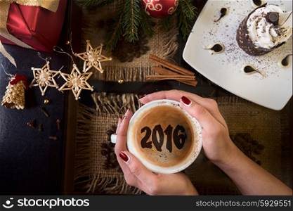 Hands holding mug of coffee close-up, on new year background