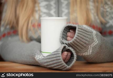 Hands holding mug of hot drink. Shallow depth of field.