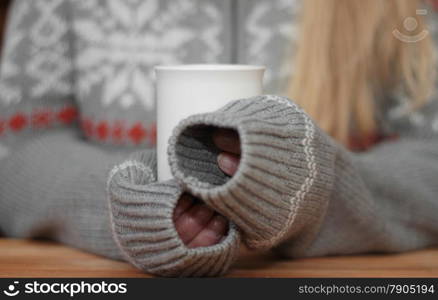 Hands holding mug of hot drink. Shallow depth of field.