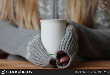 Hands holding mug of hot drink. Shallow depth of field.