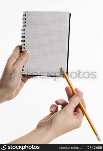 hands holding notebook with pencil
