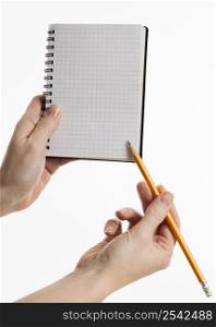 hands holding notebook with pencil