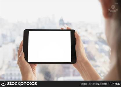 hands holding tablet with defocused background