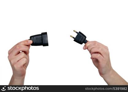 hands holding two prong plug