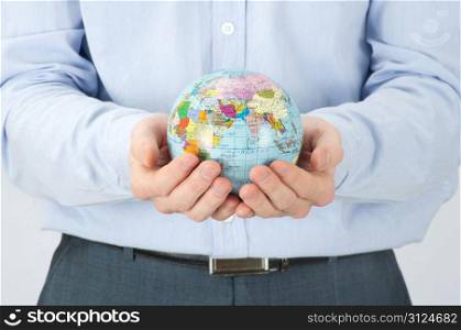 Hands holdings a globe on white