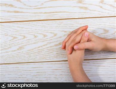 Hands making a gesture on a wooden background