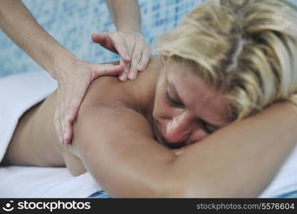 hands massaging her back - A pretty woman getting a shoulder and back massage at spa and wellness center