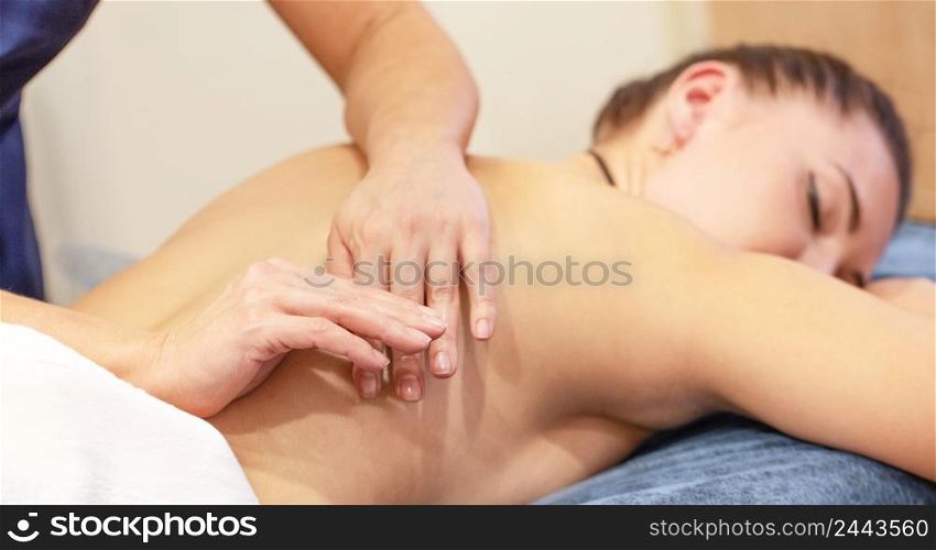 Hands of a massage therapist doing massage on the back of a young girl. Hands of a massage therapist doing massage on the back of young girl