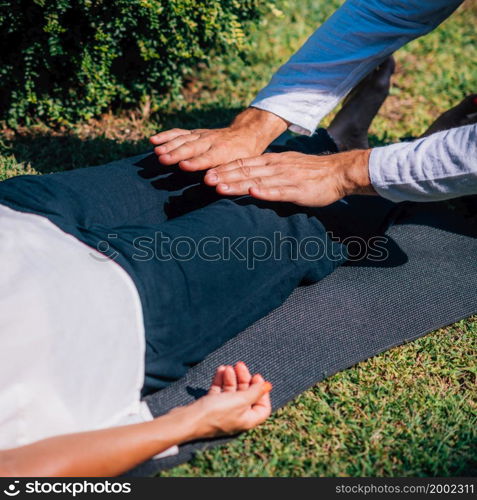 Hands of a Reiki therapist healing and balancing energy points in feet. Energy healing concept. Reiki Foot Treatment