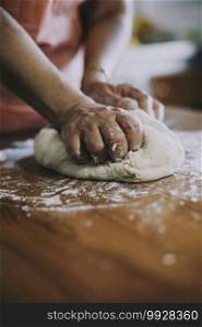 Hands of a woman making dough on a wooden table in Turkey