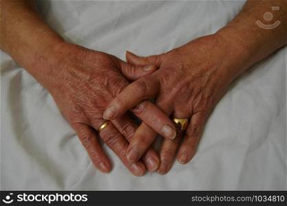 Hands of an old woman, old, clean with rings and other ornaments.