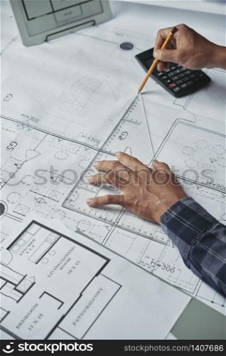Hands of architect drawing blueprint of the house. Designing new house