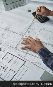 Hands of architect drawing blueprint of the house. Designing new house