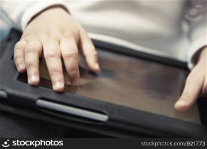 Hands of baby with digital tablet