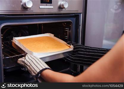 Hands of baker woman female bakery holding dough bread fresh on front oven