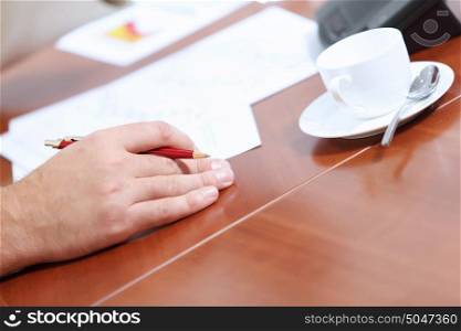 Hands of businessman laying on table. Image of businessman&rsquo;s hands laying on table with pen