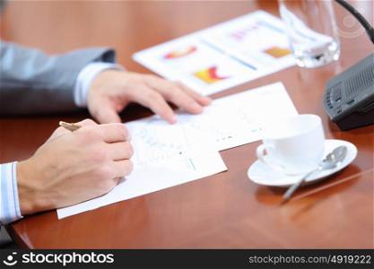 Hands of businessman writing. Image of businessman&rsquo;s hands signing documents at meeting