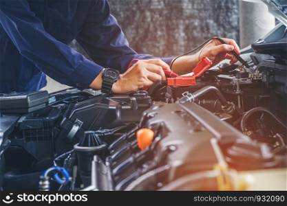 Hands of car mechanic working in auto repair service.