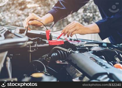 Hands of car mechanic working in auto repair service.