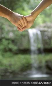 Hands Of Couple At Waterfall