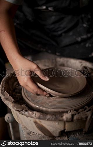 Hands of craftsman artist working on pottery wheel.Selective Focus. Hands of craftsman artist working on pottery wheel.