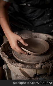 Hands of craftsman artist working on pottery wheel.Selective Focus. Hands of craftsman artist working on pottery wheel.