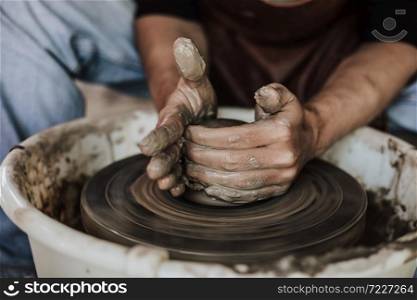 Hands of craftsman artist working on pottery wheel.Selective Focus