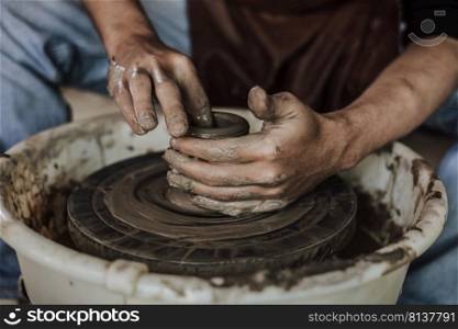Hands of craftsman artist working on pottery wheel.Selective Focus  