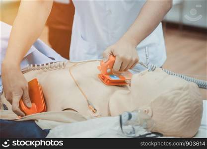 hands of doctor holding defibrillator electrods, performing defibrillation or electropulse therap