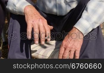 Hands of elderly homeless man smoking a cigarette