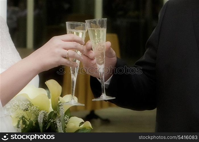 Hands of engaged couple toasting at their wedding day