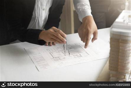 Hands of Engineers working on blueprint at a workplace, Construction and building concept
