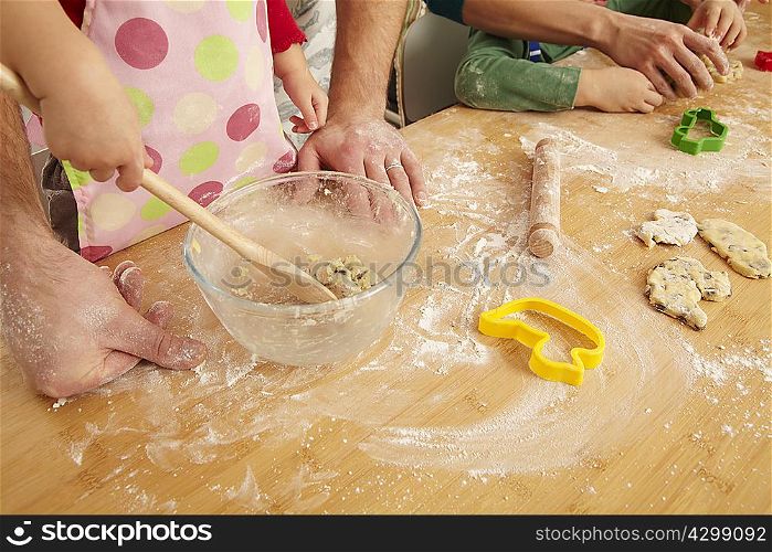 Hands of family cooking together