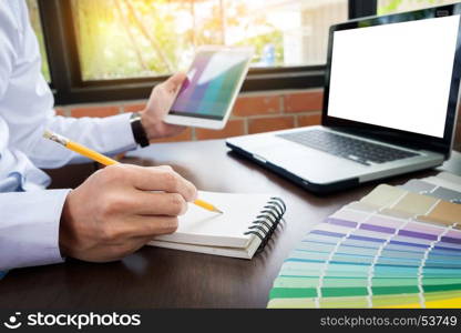 Hands of male hipster modern graphic designer in office working with colour samples. man at workplace choosing colour swatches, closeup. Creative people concept