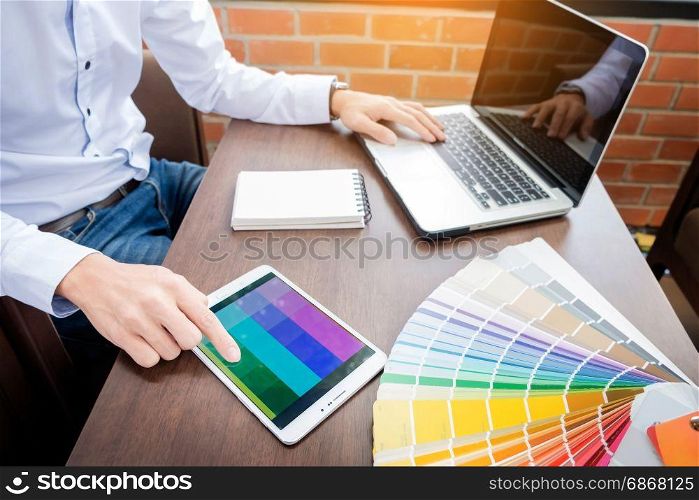 Hands of male hipster modern graphic designer in office working with colour samples. man at workplace choosing colour swatches, closeup. Creative people concept