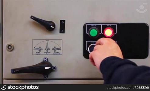 hands of man turn off and block electrical equipment from control panel, close-up