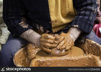 Hands of man working and shaping clay, potter in pottery, craft detail, creation