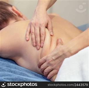Hands of massage therapist knead muscles on back of a young girl. Advertising spa or massage salon. Hands of massage therapist knead muscles on back of young girl