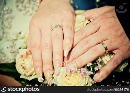 hands of newly married with wedding bouquet