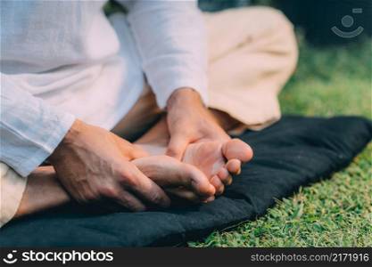 Hands of Reiki therapist doing self-treatment. Energy healing concept. Reiki Foot Self-Treatment.