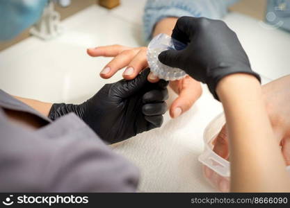 Hands of the manicure master removing dust from nails with a brush cleaning nails in nail salon. Hands of the manicure master removing dust from nails with a brush cleaning nails in nail salon.