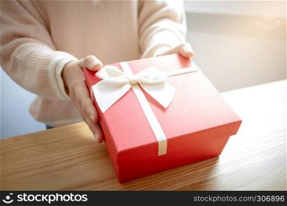 hands of woman present a red gift box, surprise for valentine concept.