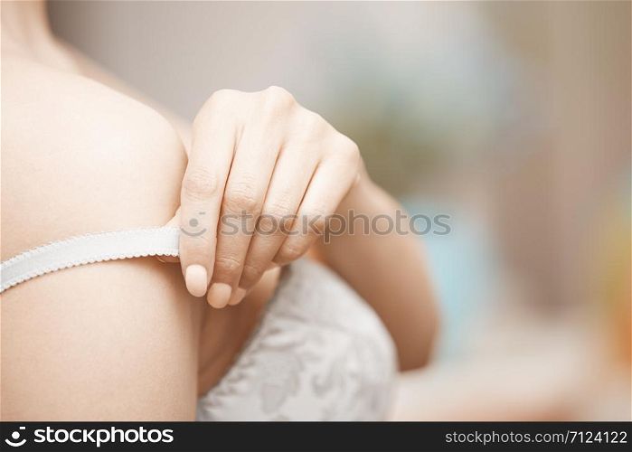 Hands of woman undressing brassiere. Close-up photo