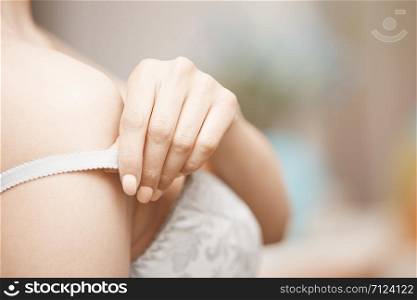 Hands of woman undressing brassiere. Close-up photo