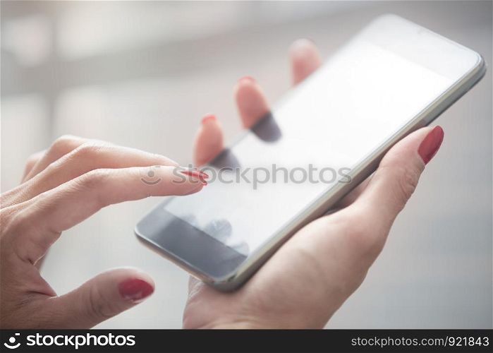 Hands of woman using smartphone