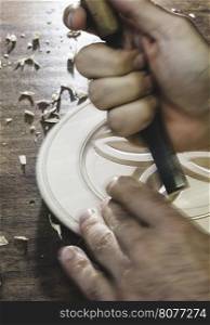 Hands of woodcarver make ??wooden bowl. Close up