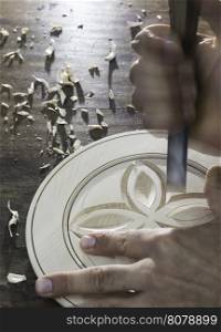 Hands of woodcarver make ??wooden bowl. Close up