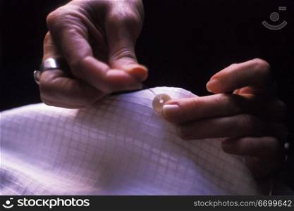 Hands Sewing on a Button