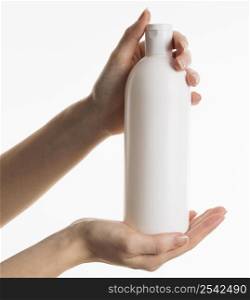 hands showing cosmetic bottle