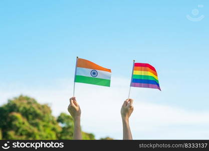 hands showing LGBTQ Rainbow and India flag on nature background. Support Lesbian, Gay, Bisexual, Transgender and Queer community and Pride month concept